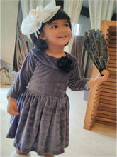 Load image into Gallery viewer, Girl wearing grey 3/4th sleeves velvet party frock with bow attachment and white hair accessory and holding a fan

